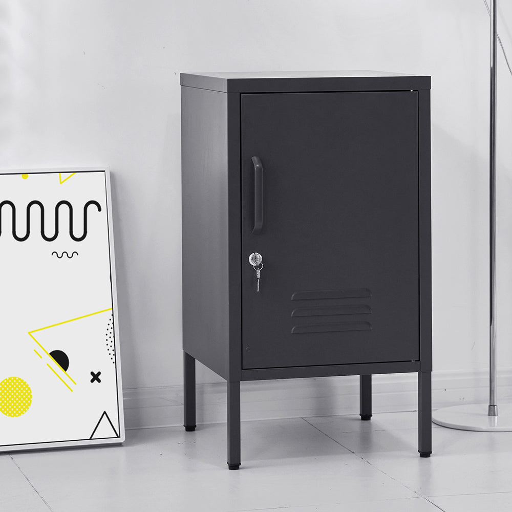 Black metal cabinet with a key on a white floor and wall.