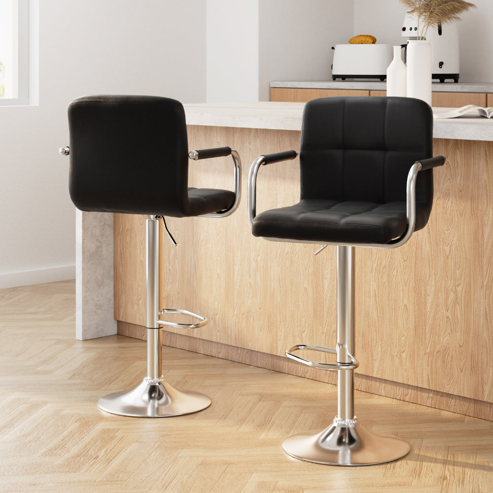 Two black bar stools with chrome bases in a kitchen setting.