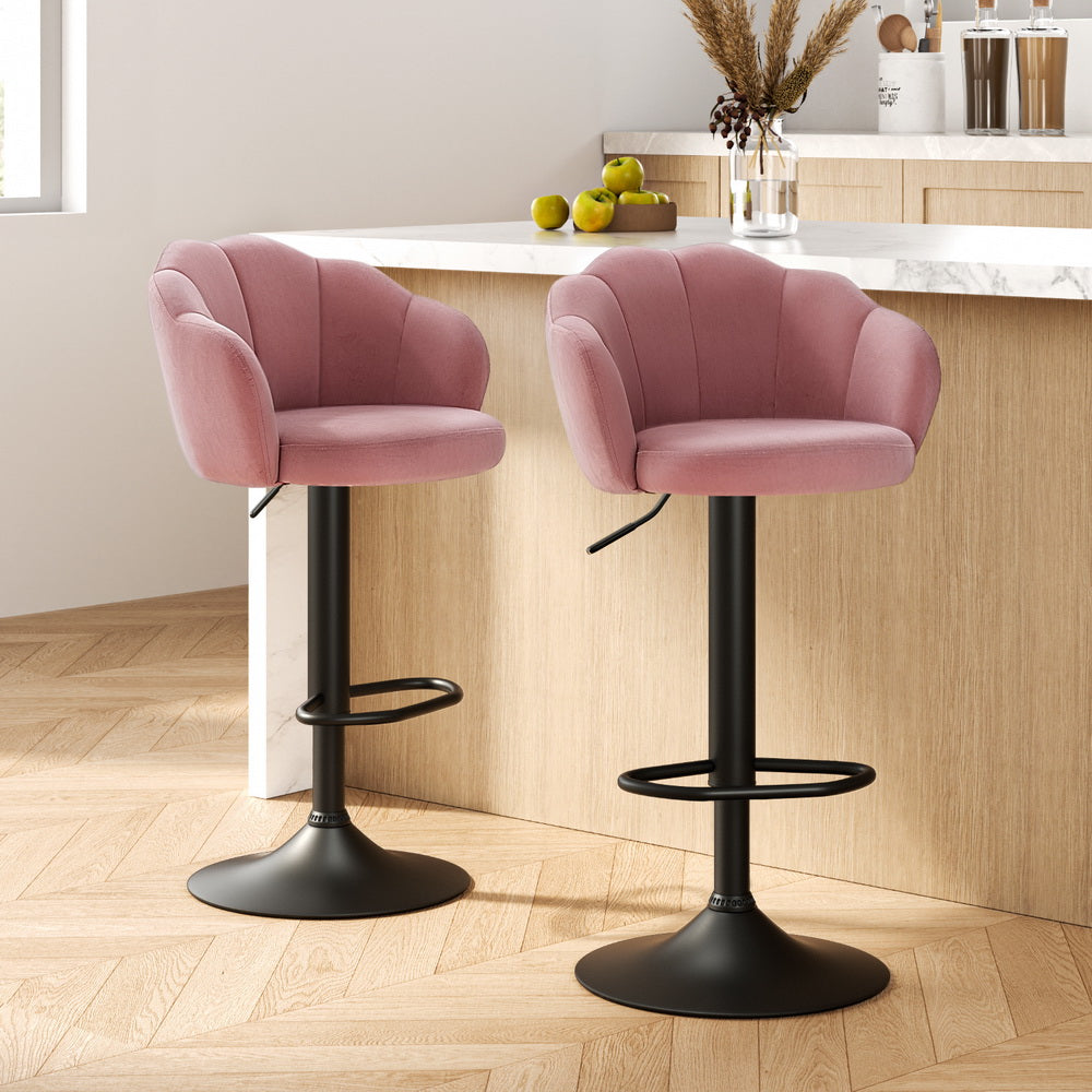 Two pink bar stools with black bases in a kitchen setting.