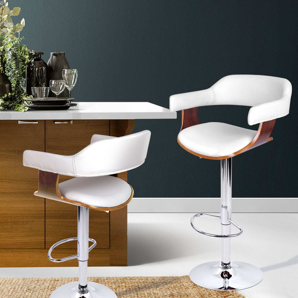 Two white bar stools with wooden seats in a kitchen setting.