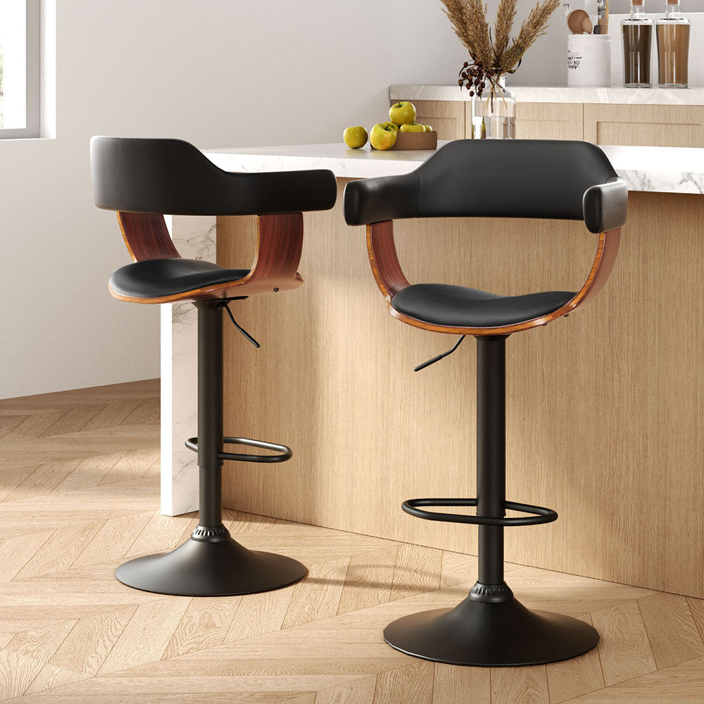 Two black bar stools with wooden seats in a kitchen setting.