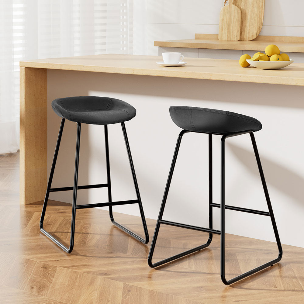 Sleek NORDIQE Ludovic bar stools in black faux leather — modern design with a minimalist metal frame for a stylish look.