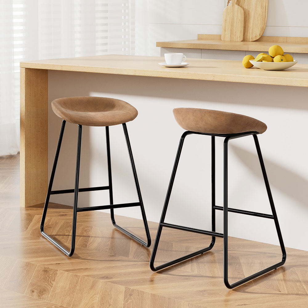 Ludovic bar stools by NORDIQE in brown with a curved suede seat and sleek black metal frame, perfect for modern kitchens.