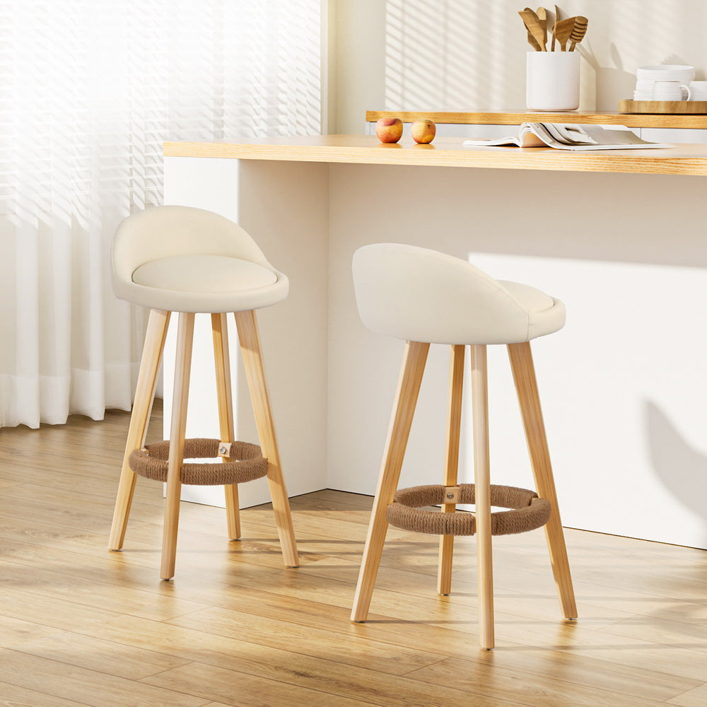 Two beige bar stools with wooden legs in a kitchen setting.