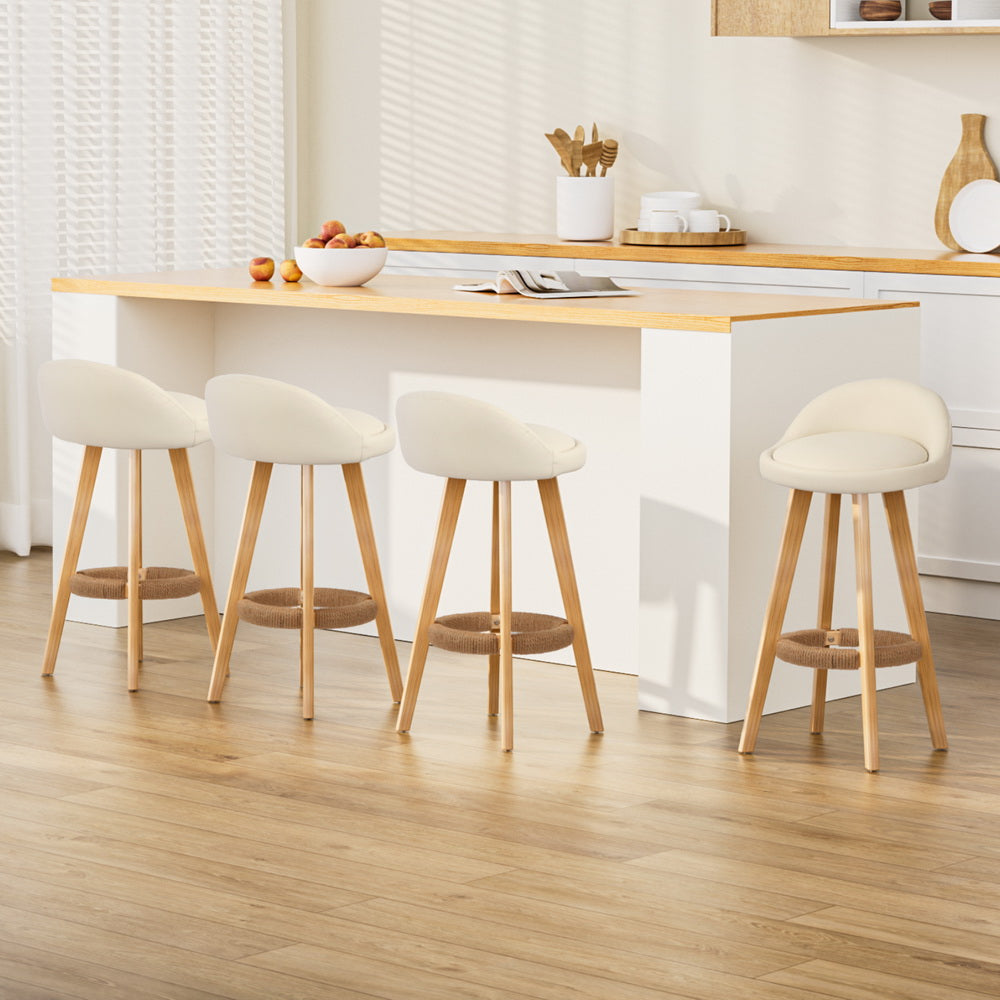 Elegant Dalvey bar stools in beige with soft cushioning and natural wood legs, enhancing a modern kitchen aesthetic.