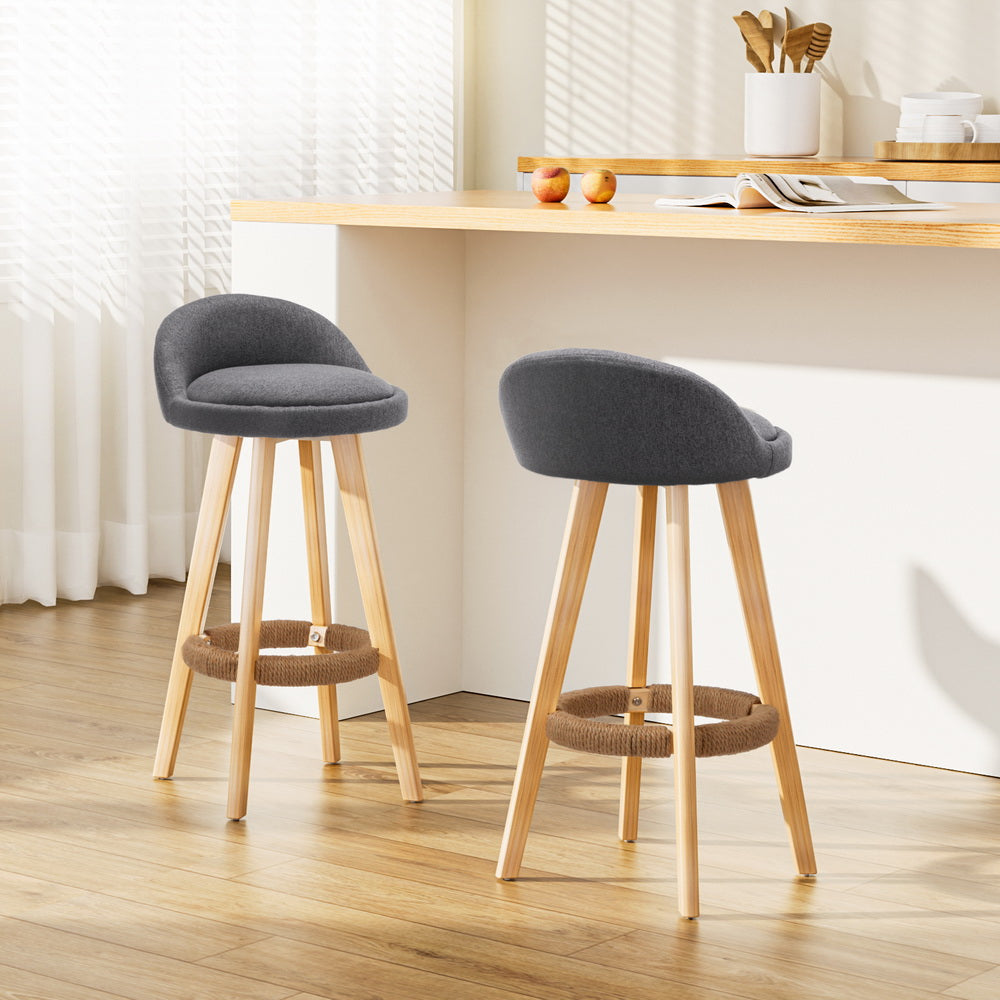 Two gray cushioned stools with wooden legs in a kitchen setting.