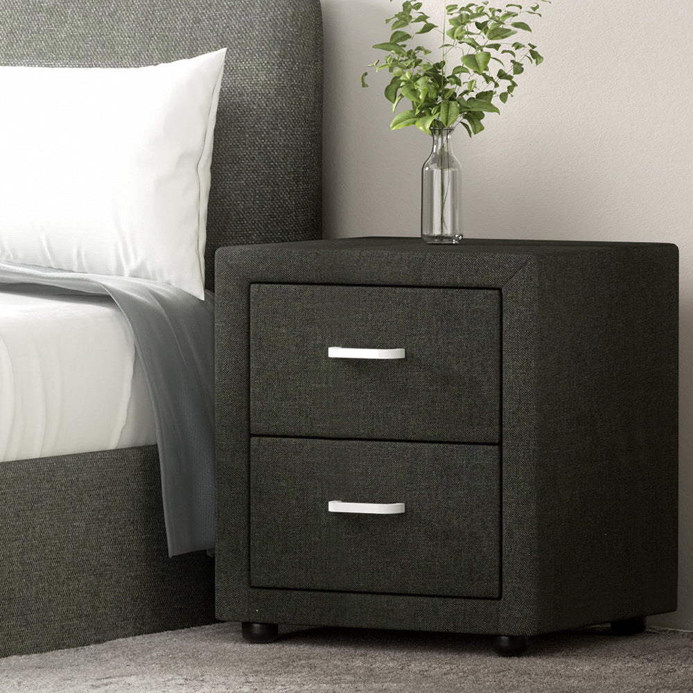 Dark gray nightstand with two drawers next to a bed with white bedding.