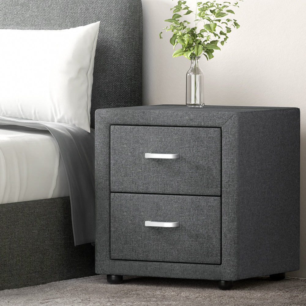 Gray nightstand with two drawers next to a bed with white bedding.