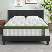 Mattress on a bed with a black headboard in a room setting.