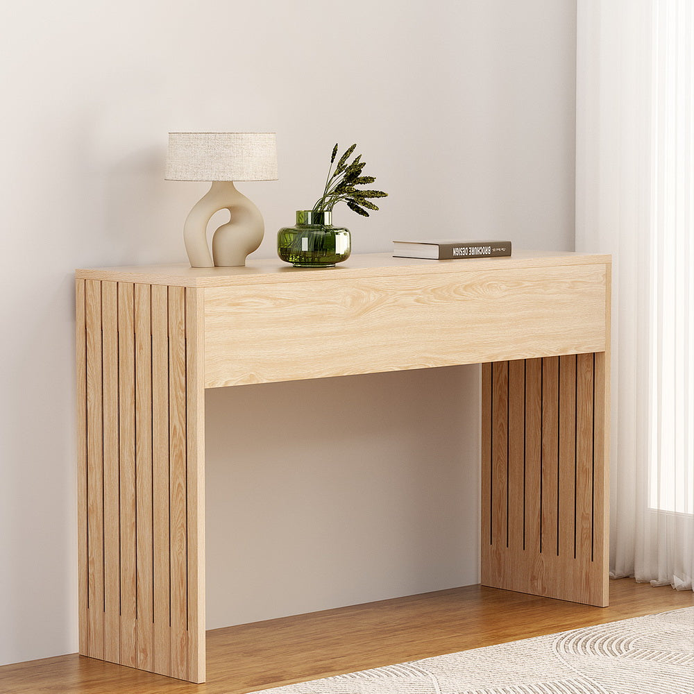 Wooden console table with decorative items against a white wall