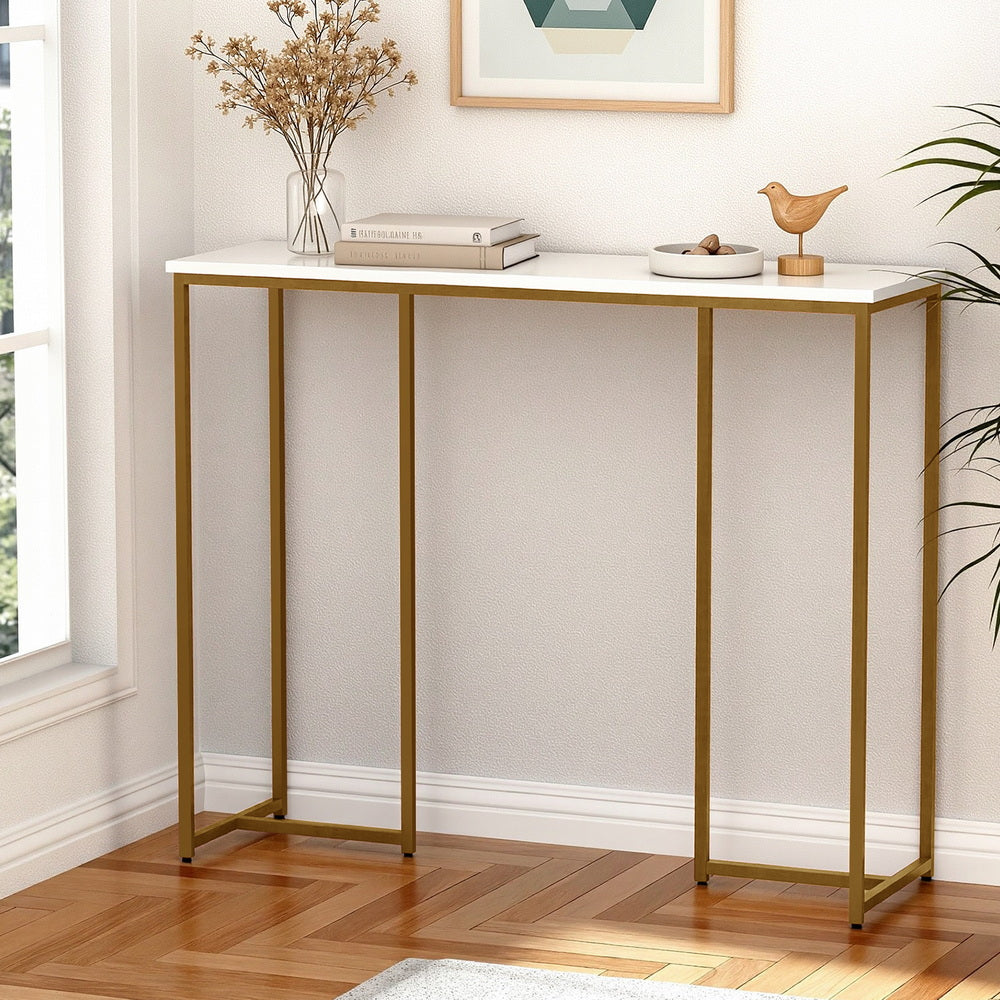 Console table with gold legs and white top in a room with decor elements.