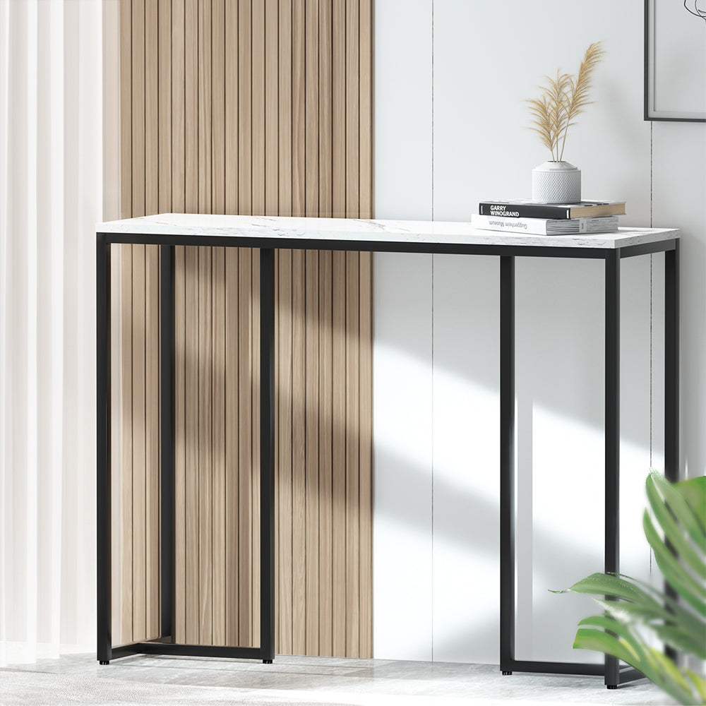 Modern console table with a white top and black metal frame against a neutral wall.