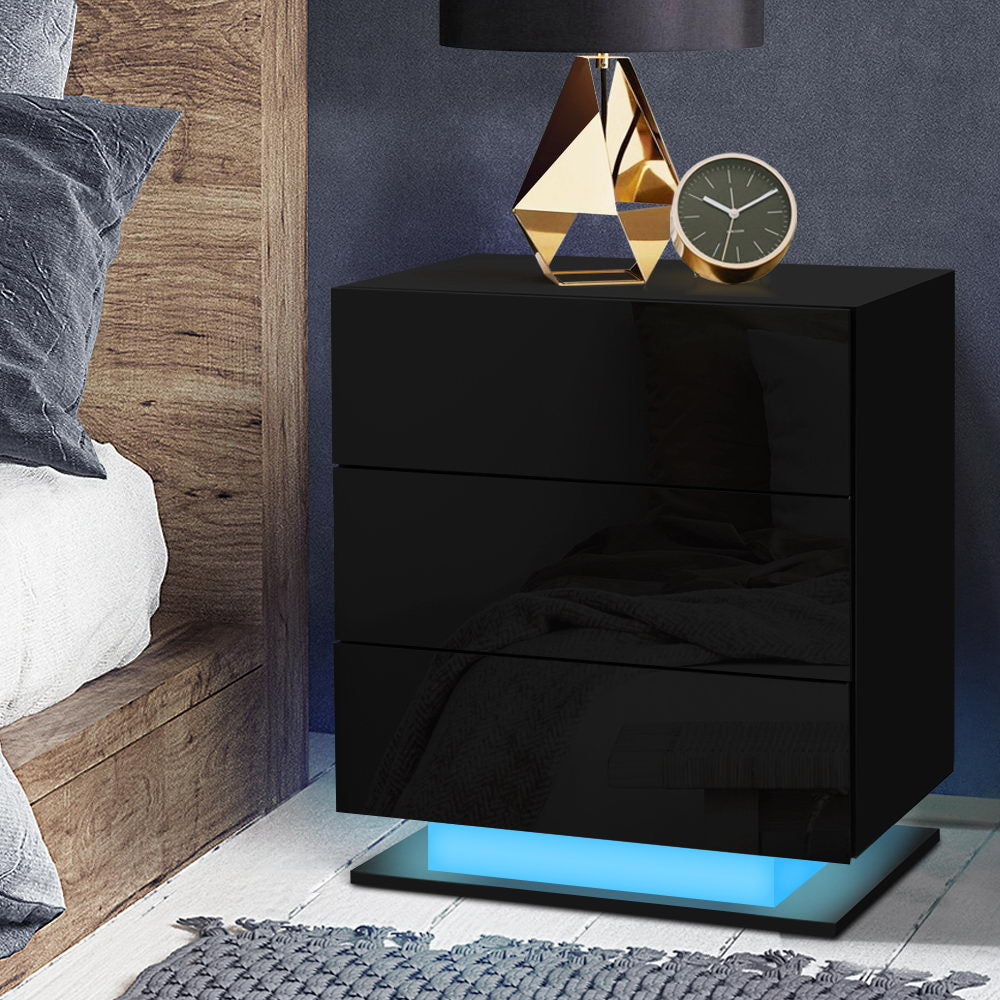 Black nightstand with gold lamp and clock in a bedroom setting