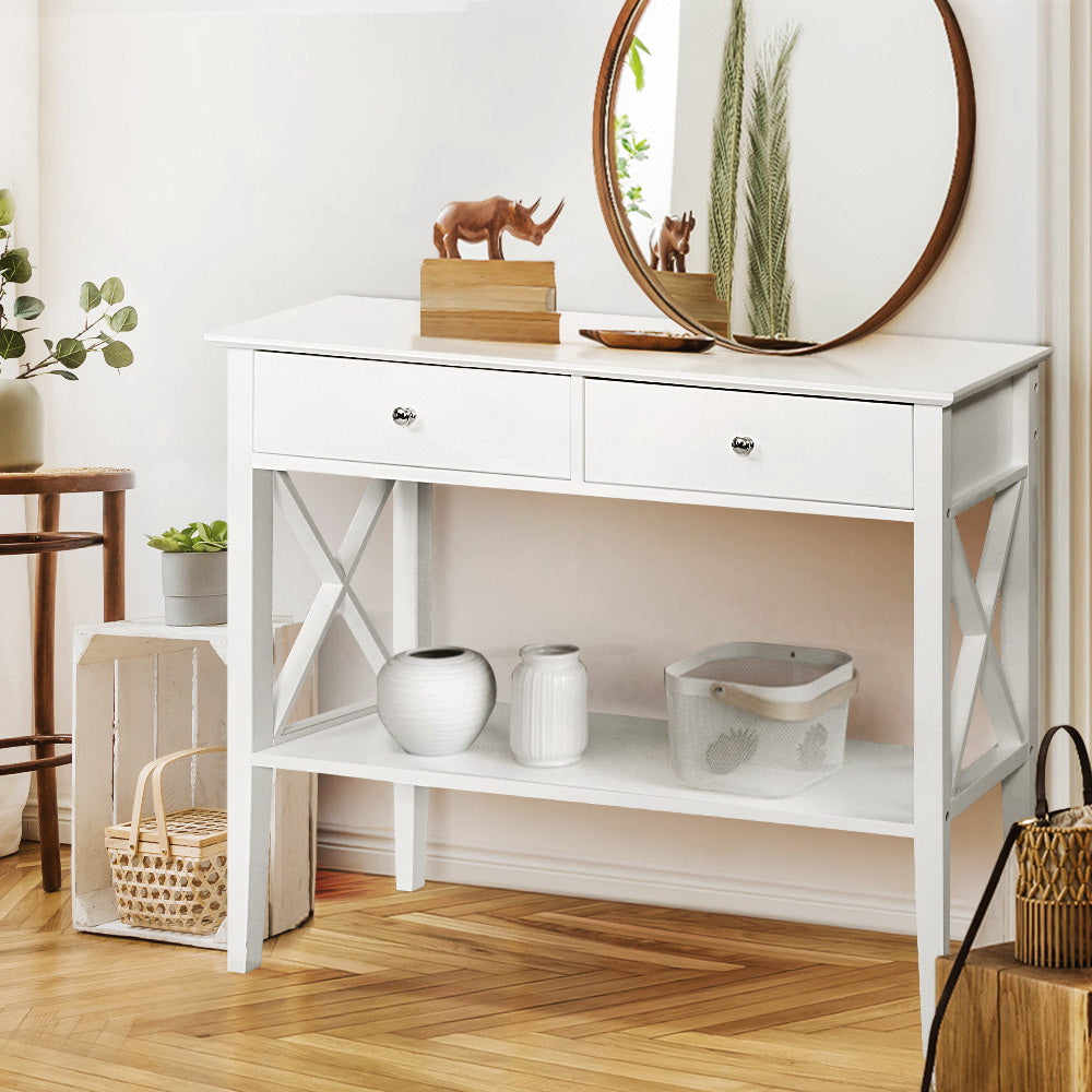 White console table with decorative items in a room setting
