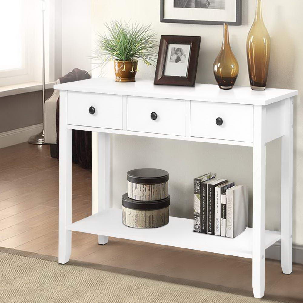 White console table with decorative items in a living room setting