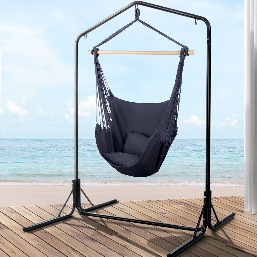 Hammock chair in grey fabric with black stand by NORDIQE, featuring a supportive pillow.