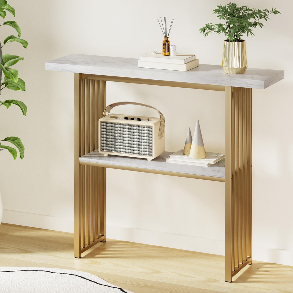 Console table with marble top and gold frame in a room setting.