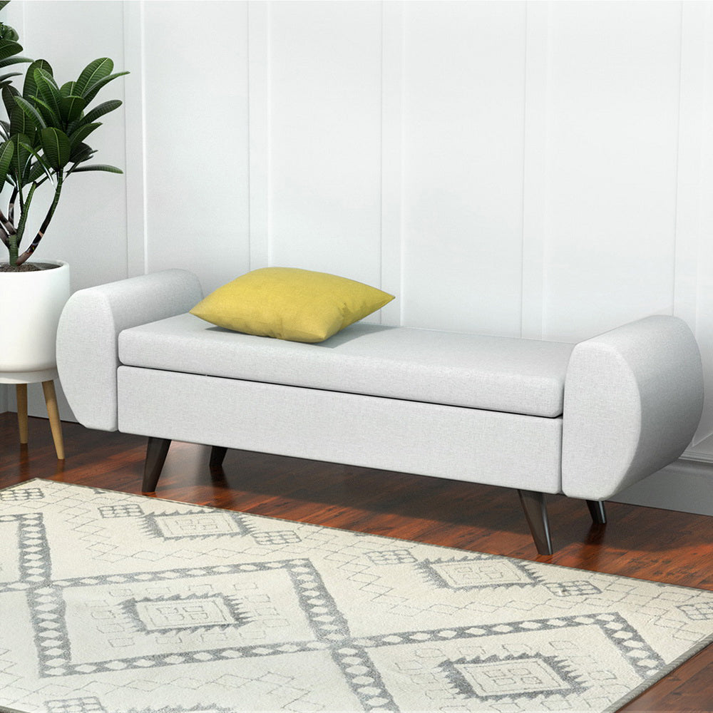 Stylish NORDIQE Sexon Storage Ottoman in grey fabric with rounded edges — features a hidden storage compartment and wooden legs.