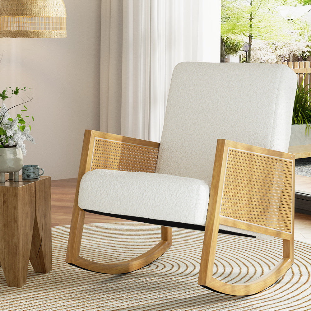 Rattan armchair with white cushion in a room with a wooden side table and plants.