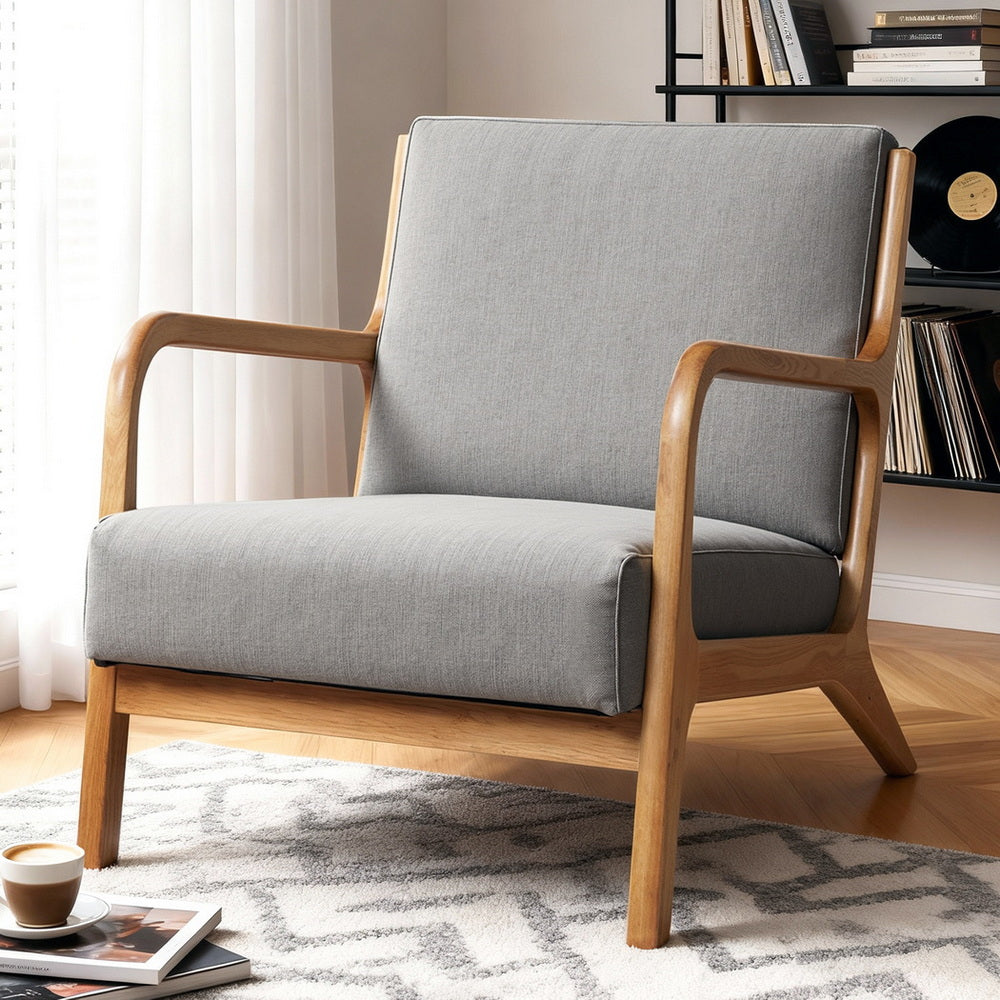 Nimblos Armchair by NORDIQE in light grey fabric with a sleek wooden frame, blending modern design and comfort.