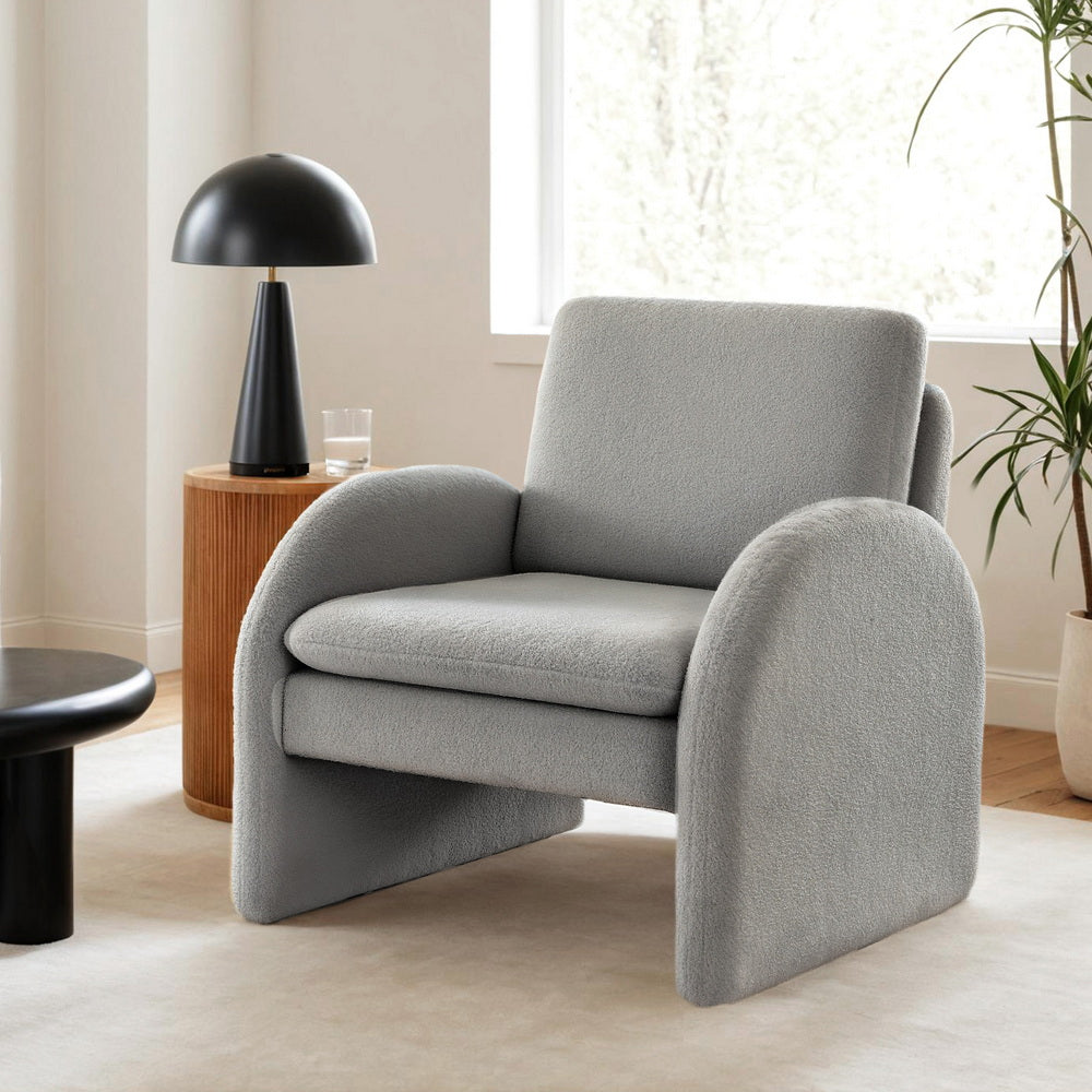 The Sagenor Lounge Chair by NORDIQE features a soft boucle grey upholstery — a modern design that enhances cozy interiors.