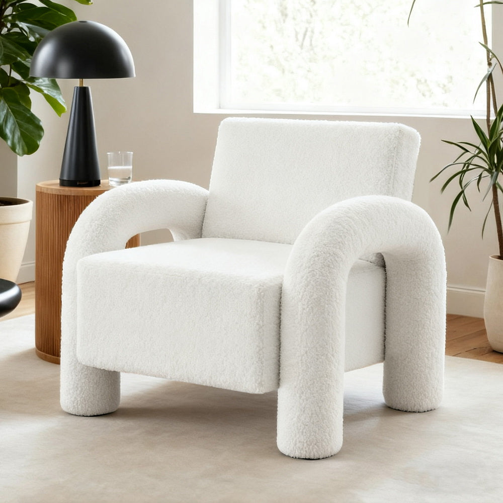 The Wealden Lounge Chair by NORDIQE features a plush boucle white fabric, offering a cozy and inviting design with rounded arms.