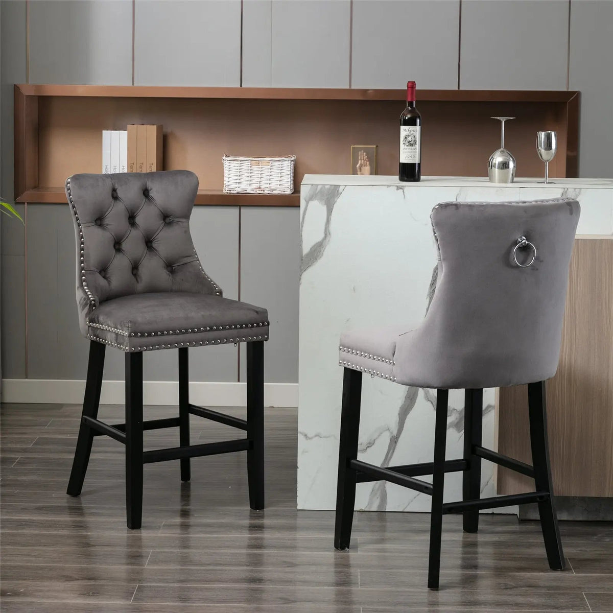 Two gray bar stools with black legs in front of a marble bar counter.