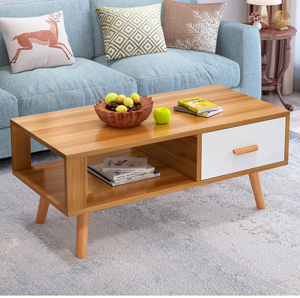 Wooden coffee table with a bowl of fruit and books in a living room setting.