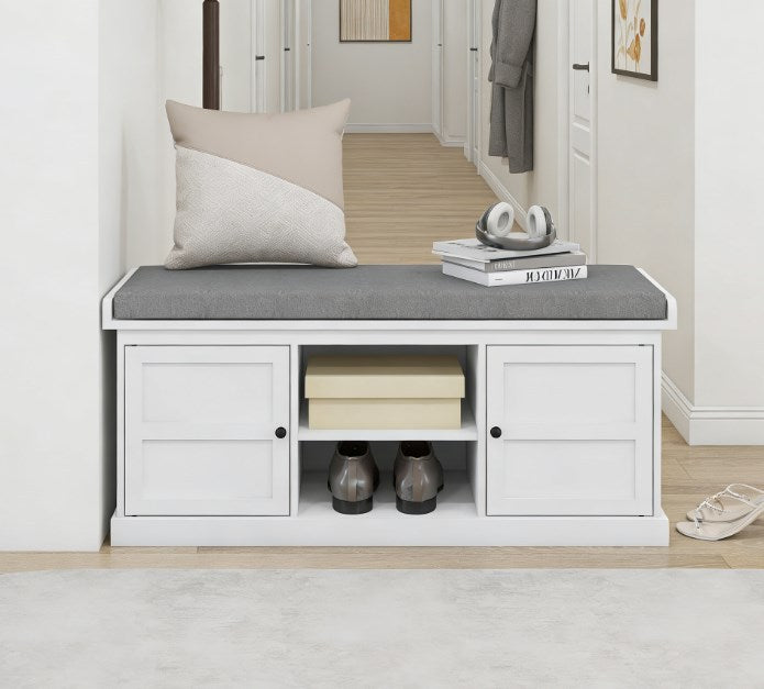 White storage bench with gray cushion in a hallway setting.